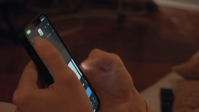 Person browsing the OpenSea marketplace on a smartphone