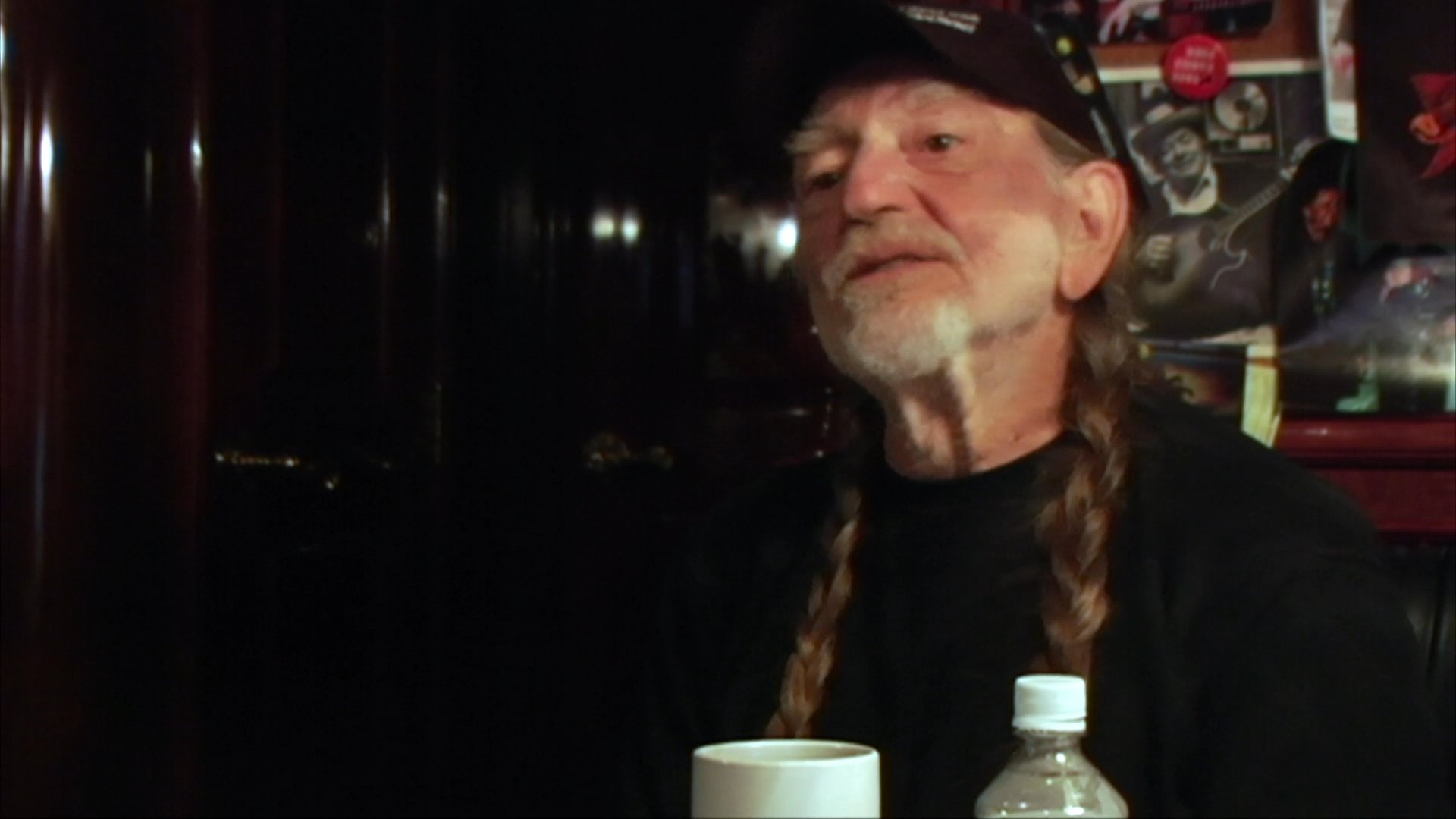Legendary country musician Willie Nelson discusses his life and work in an intimate interview setting before transitioning into a brief guitar performance.