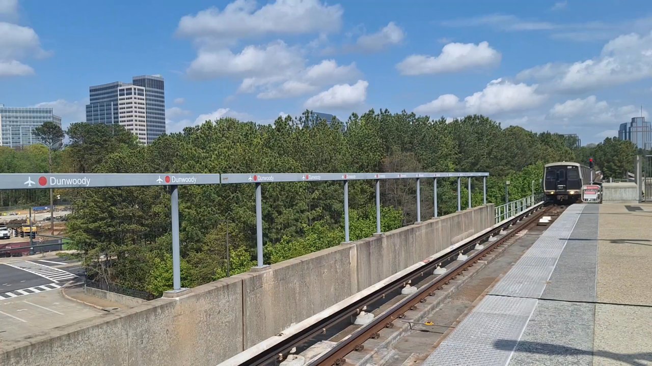 MARTA - A MARTA train is coming into the platform at Dunwoody from North Springs and Sandy Springs, and you can see Concourse at Perimeter beyond - Public Transportation Near Me - Atlanta, Georgia