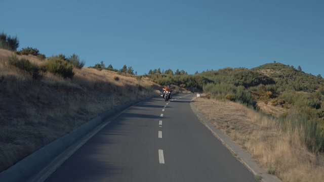 Bikers in the distance riding a downhill path