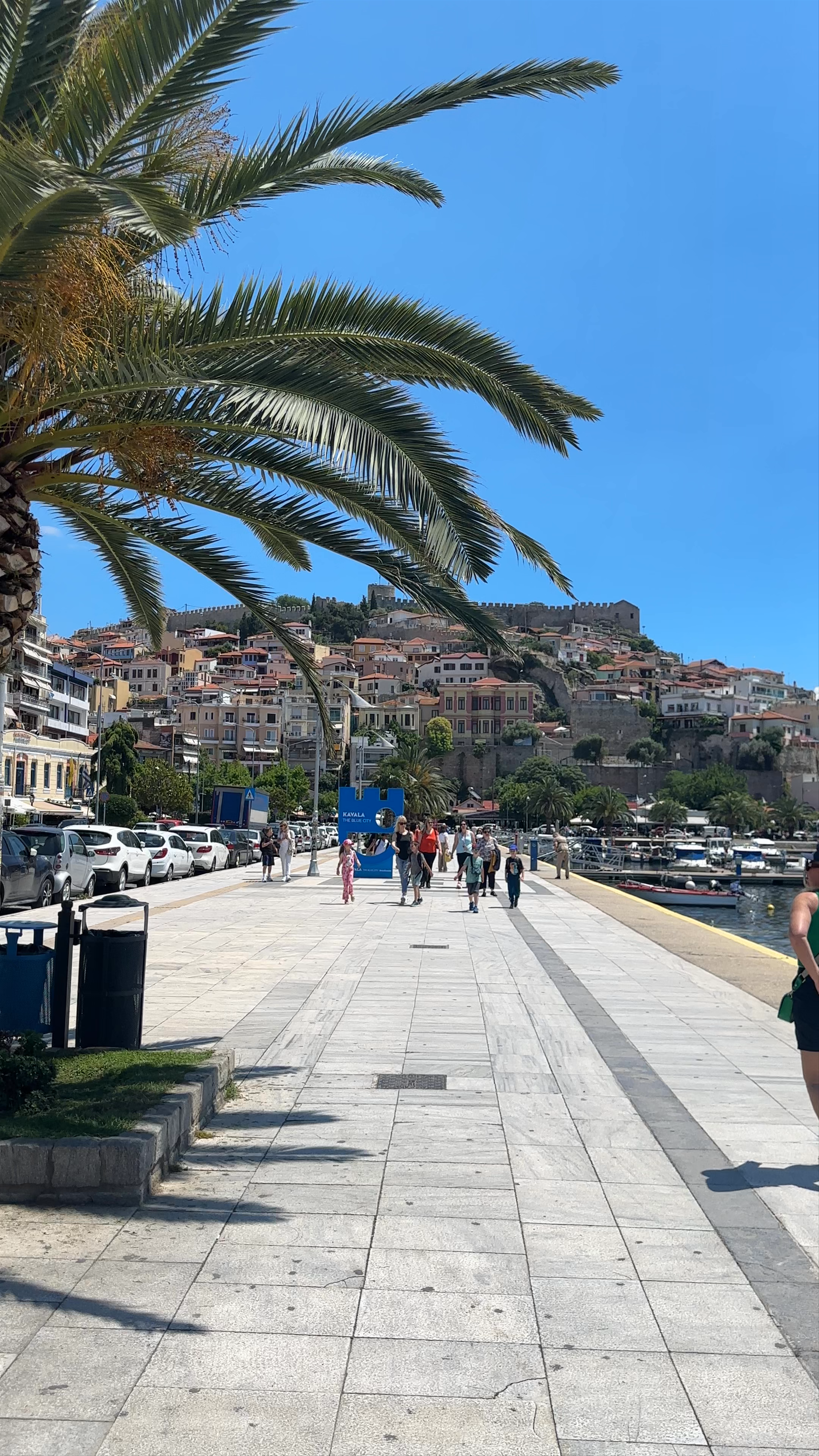 Sunny Stroll Along Kavala Marina with Castle Views