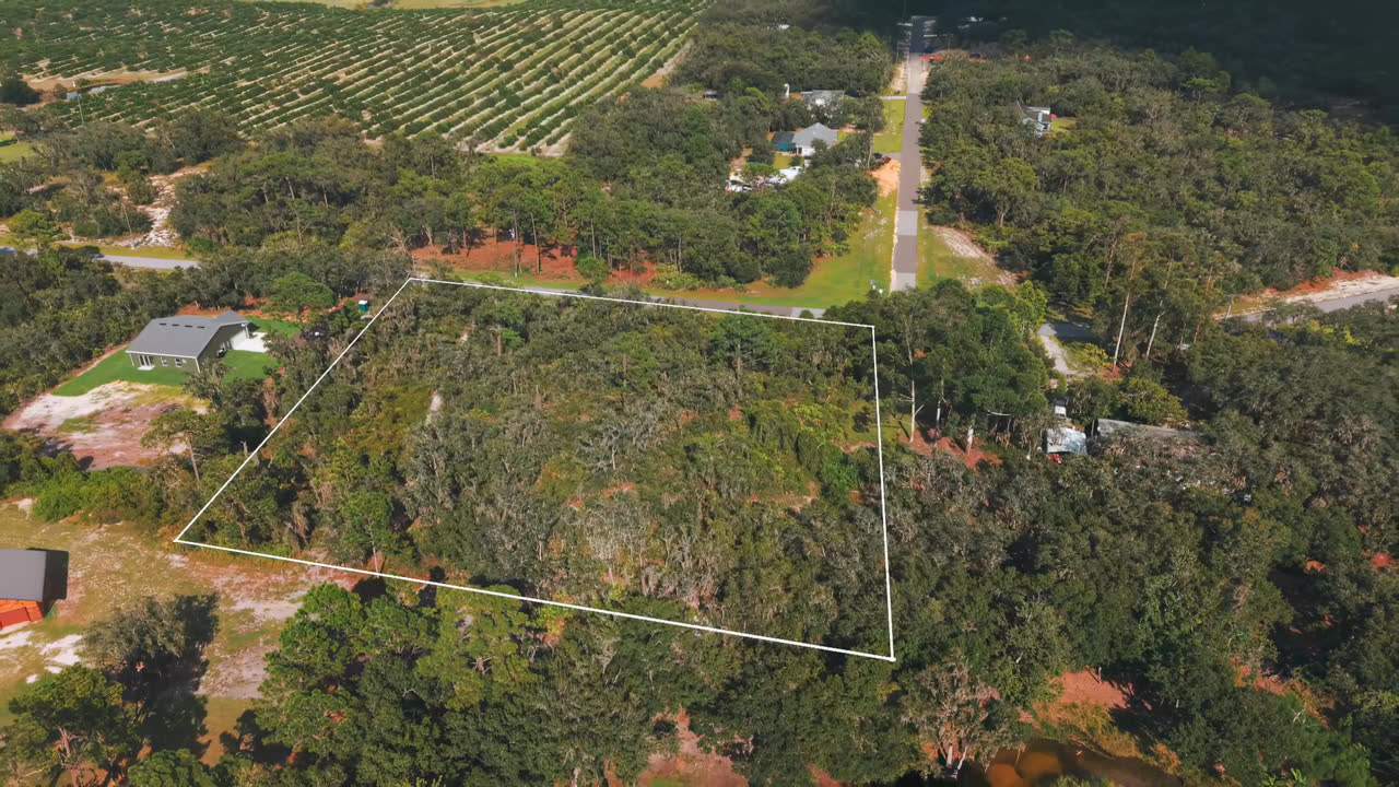 Aerial video frame of a vacant lot with the lot lines drawn on