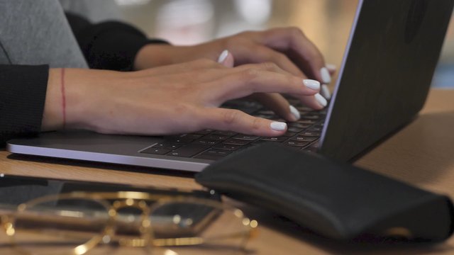 Female Hands Type on a Laptop Keyboard
