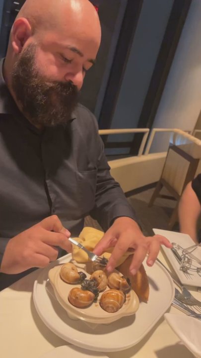 LA Prime - Taking a bite of the Traditional Escargot in Shell - Steakhouses Near Me - Los Angeles, California