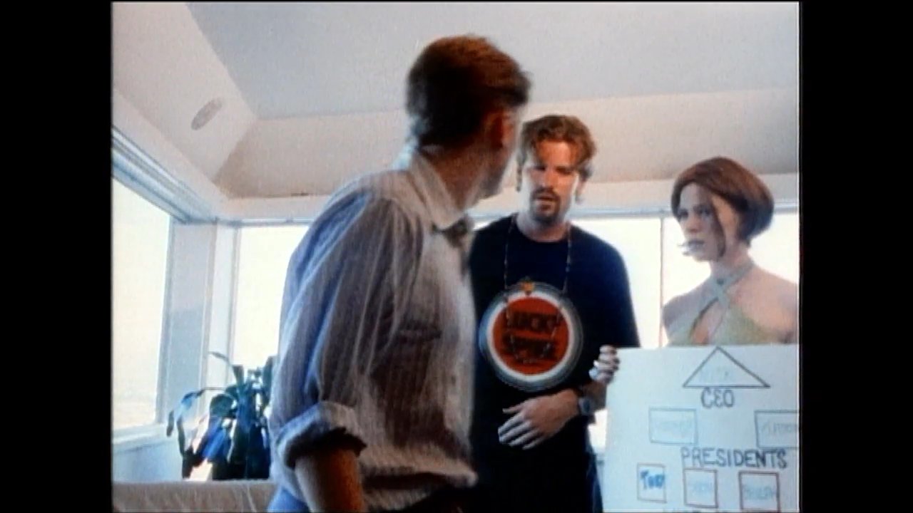 Three professionals review a company organizational chart during a discussion, followed by an exterior scene of a group gathered on a sunlit rooftop patio.
