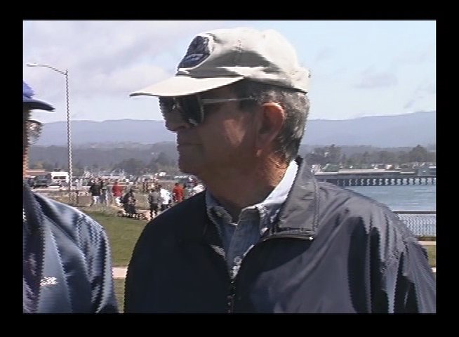 A group of older men in casual outdoor attire socialize and participate in a public park event. The sequence captures interactions among the group before shifting to a close-up of a participant observing the surroundings.