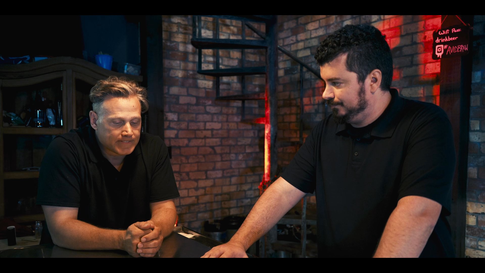 Two men in a professional setting engage in a focused, seated conversation while maintaining active eye contact.