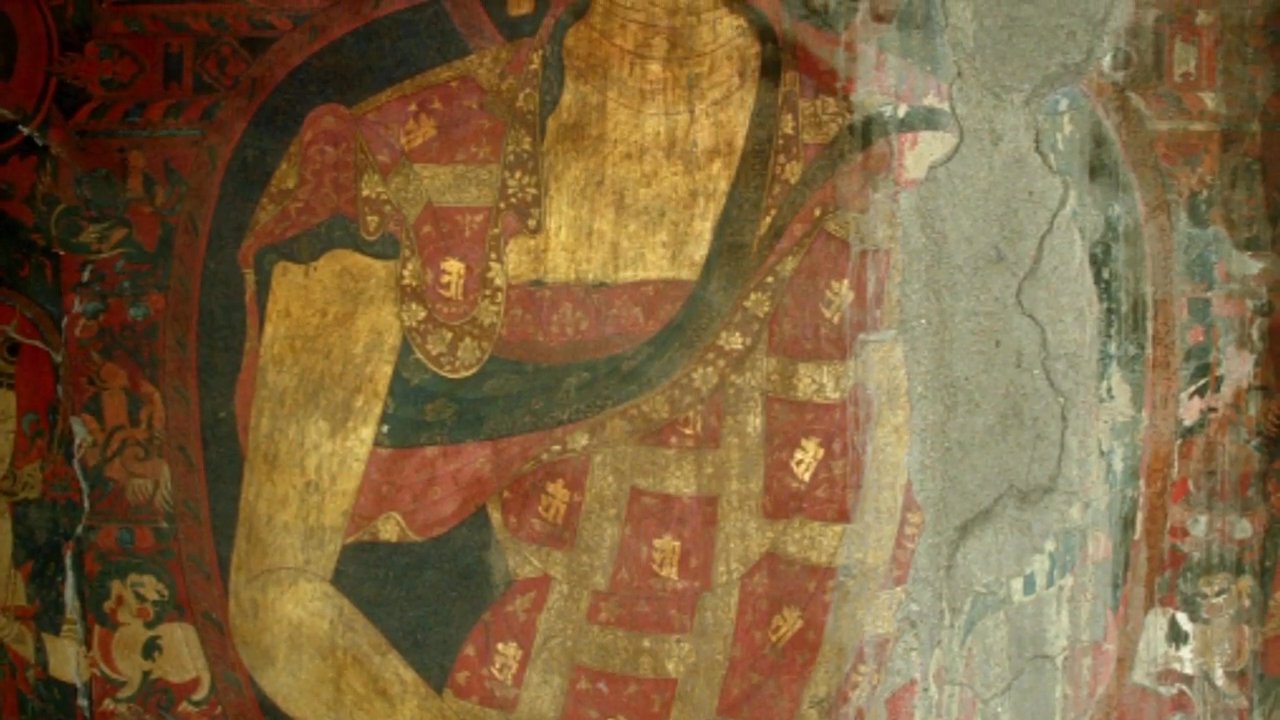 A scholar discusses the artistic significance of ancient religious murals while documenting the preserved frescoes within a traditional Tibetan monastery setting.