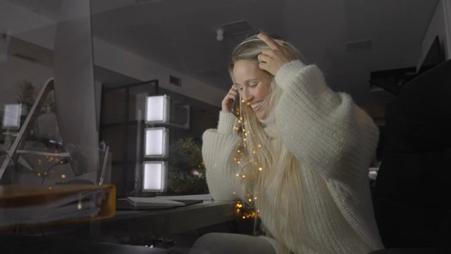 A woman talking on her phone while sitting at her desk in an office