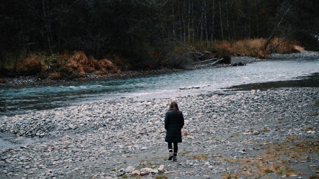 Woman strolls near a river  