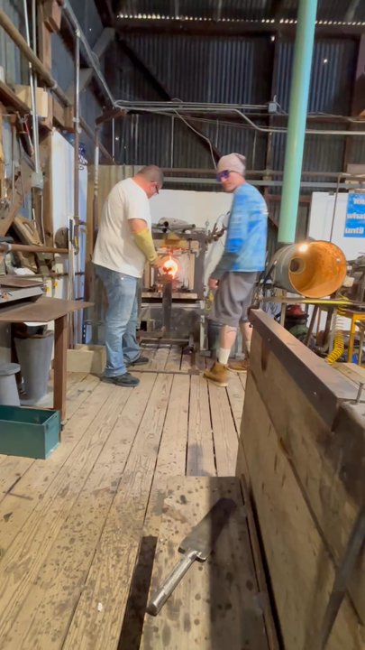 Harmony Glassworks - Spinning of molten blown glass to heat up for the next step - Art Schools Near Me - Harmony, California