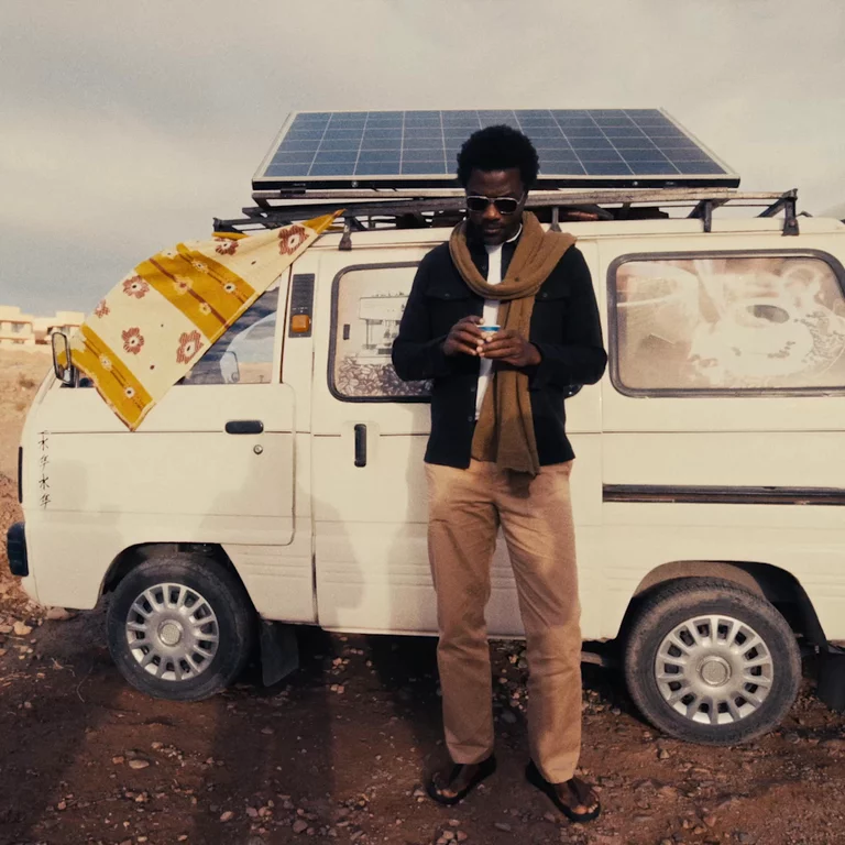 Video of man drinking an espresso next to a small white van in Morocco
