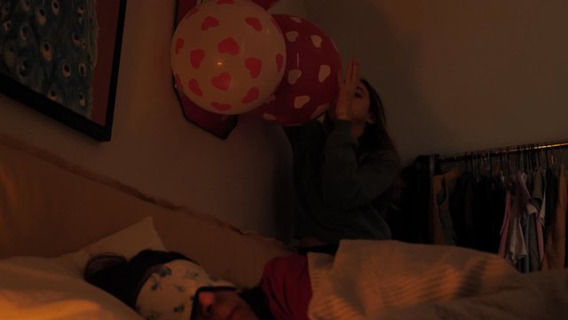 A daughter decorates her mom's room with balloons