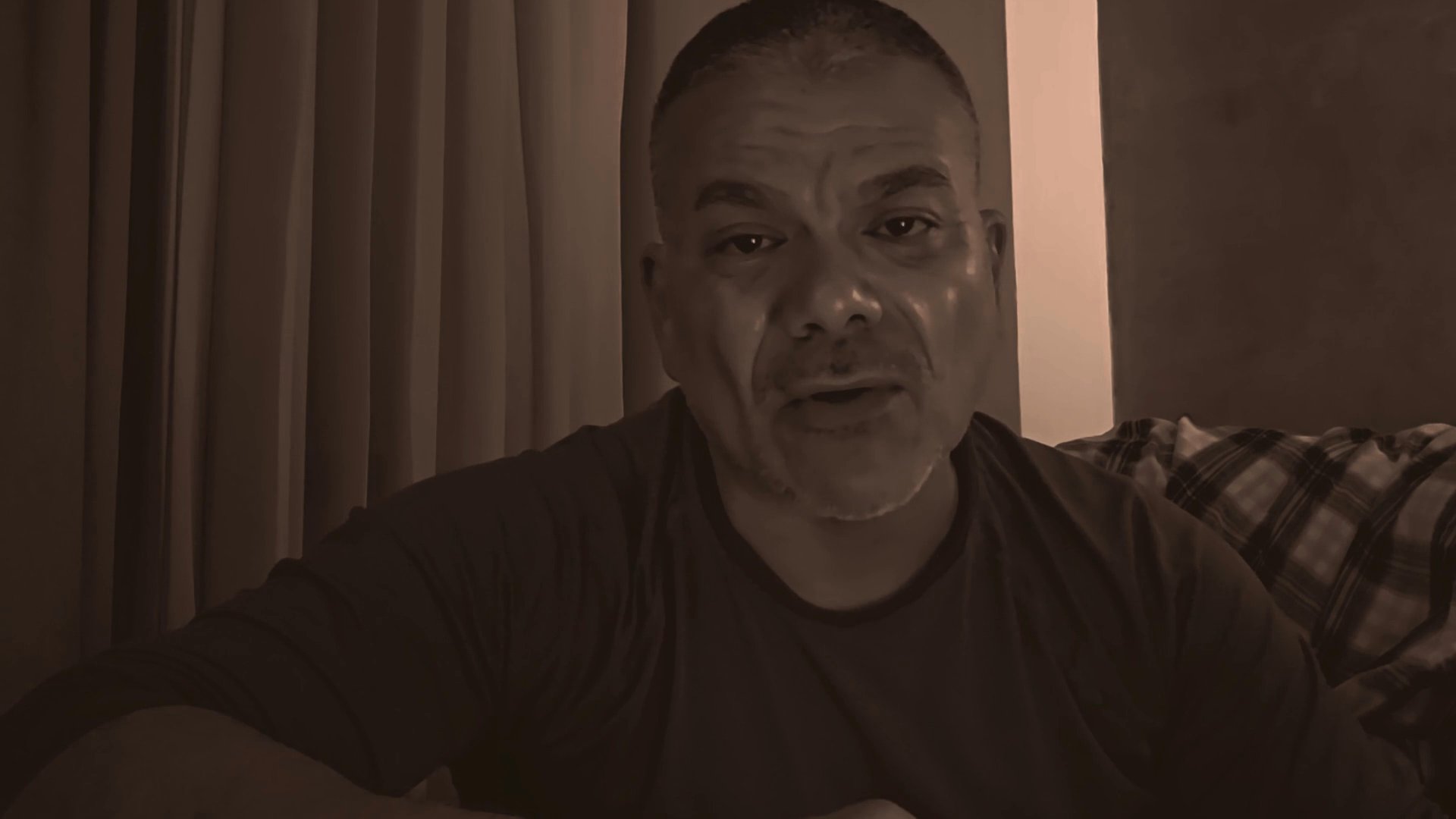 A man speaks directly to the camera in an indoor setting, occasionally gesturing with a coffee mug while delivering his narrative.
