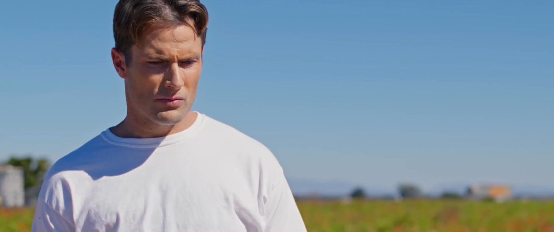 Two individuals interact in a rural chili pepper field before one gazes into a blue bowl, observing their own reflection.