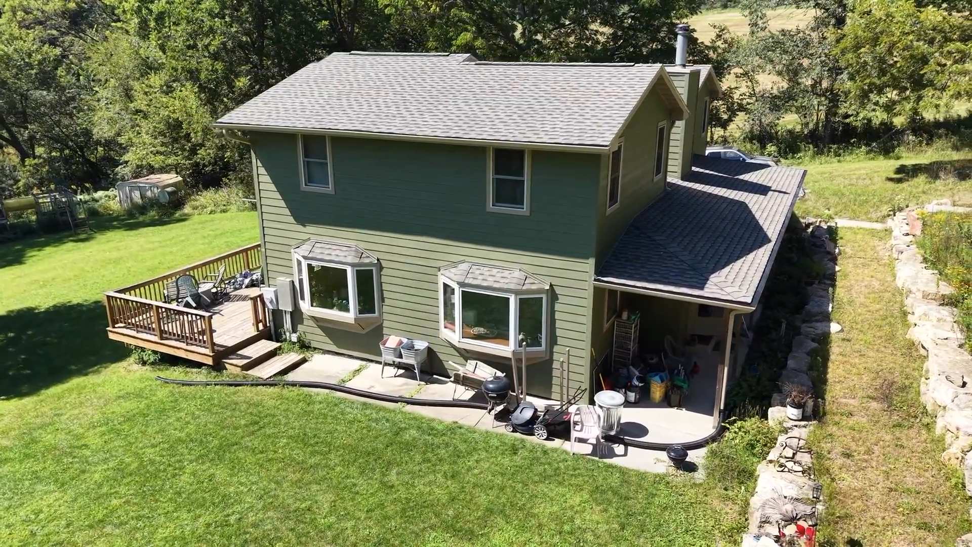 Crew installing siding and roofing underlayment on a two-story home