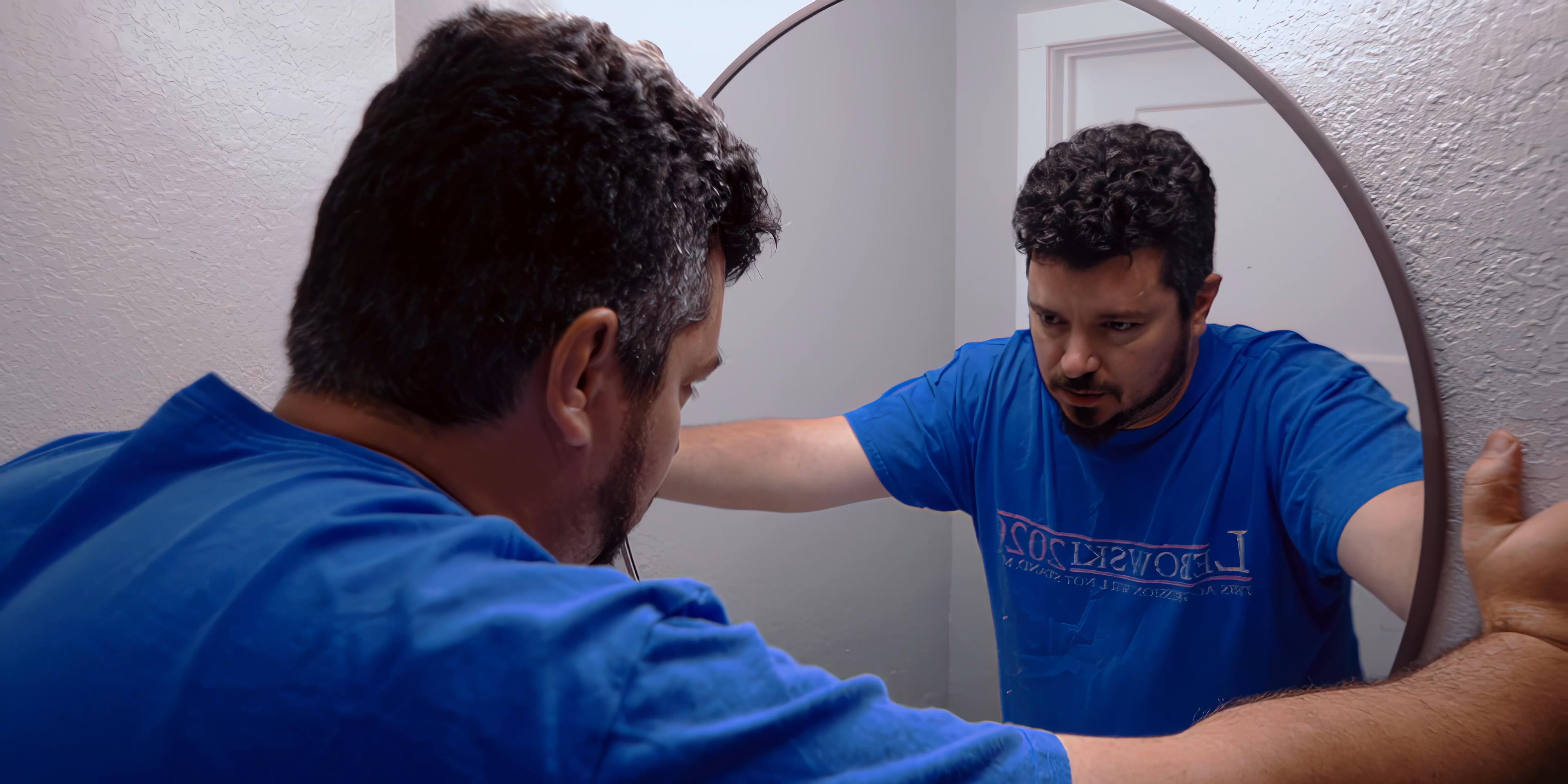 A man observes his reflection in a bathroom mirror before preparing waffles for breakfast in his kitchen.