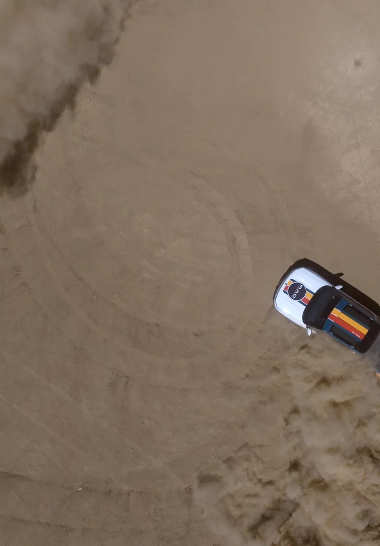 Birdseye view video of Rivian drifting on desert landscape