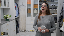 Julie Thompson holding a mug in her finished white walk-in closet with gold hardware, glass-front cabinets, and shelves of shoes, from her Coffee in the Closet testimonial video