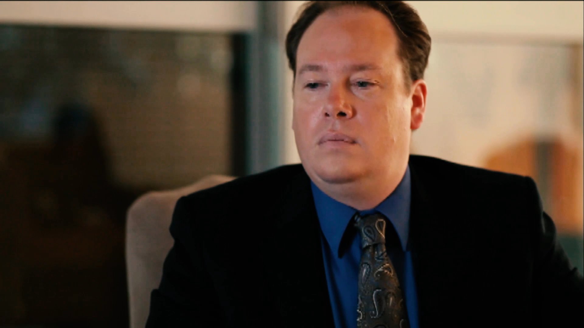 A man in traditional historical attire reading at a desk is interrupted by a sudden flash, transitioning to an office setting where professionals react with evident concern and apprehension.