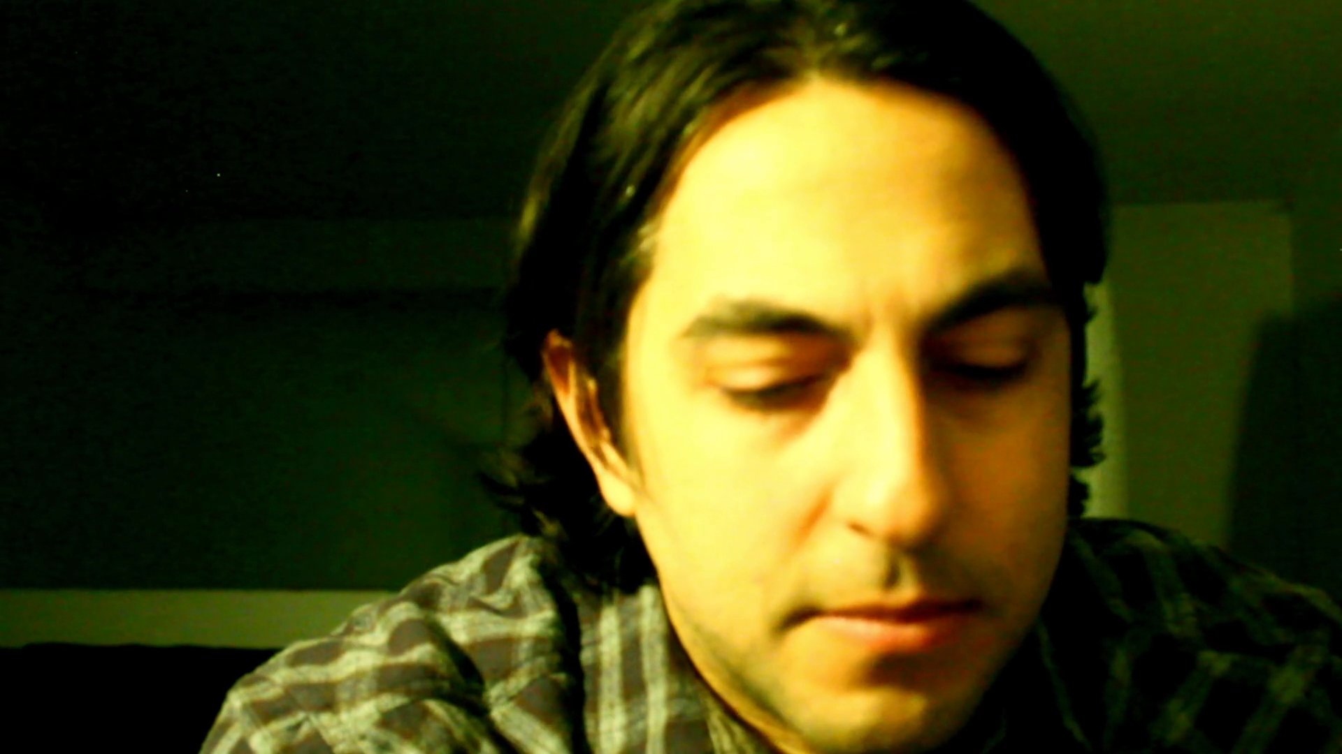 A man speaks directly to the camera, sharing thoughts while maintaining a serious and contemplative demeanor.