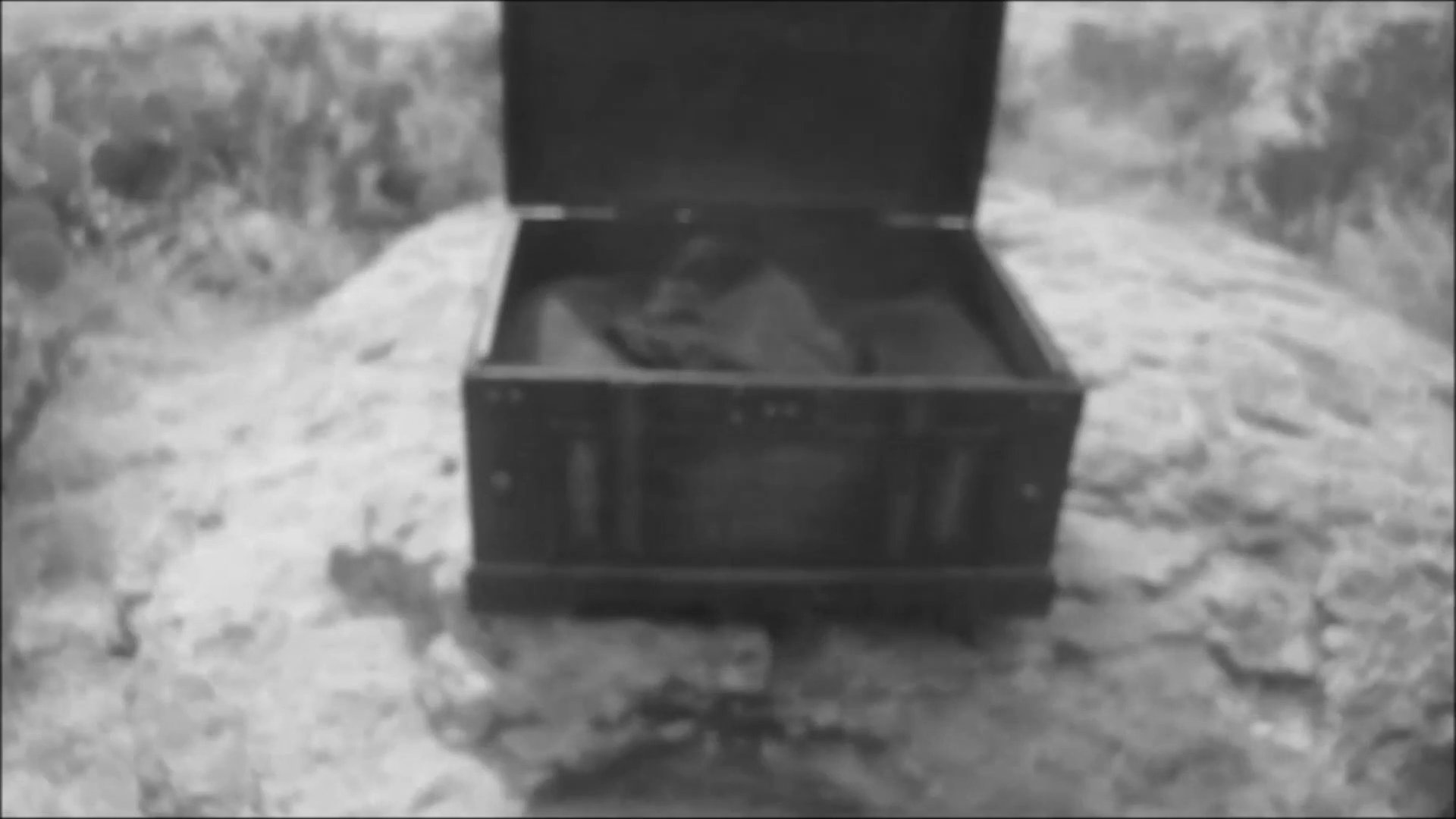 A man navigates between a past confrontation inside a house and a present-day discovery in an open field. The sequence emphasizes his psychological state as he unearths a mysterious object.
