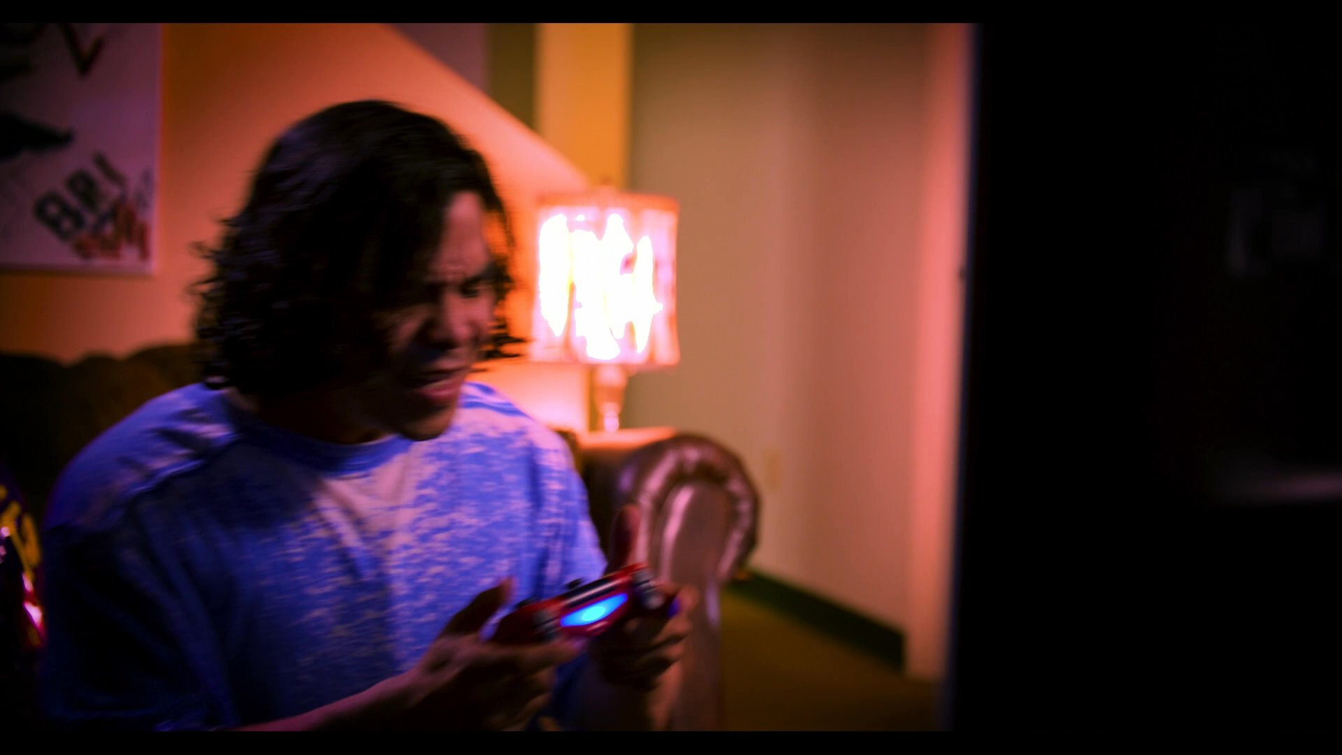 A man plays a video game before transitioning to a video call with a woman on his television screen. The two engage in an animated conversation from their respective locations.