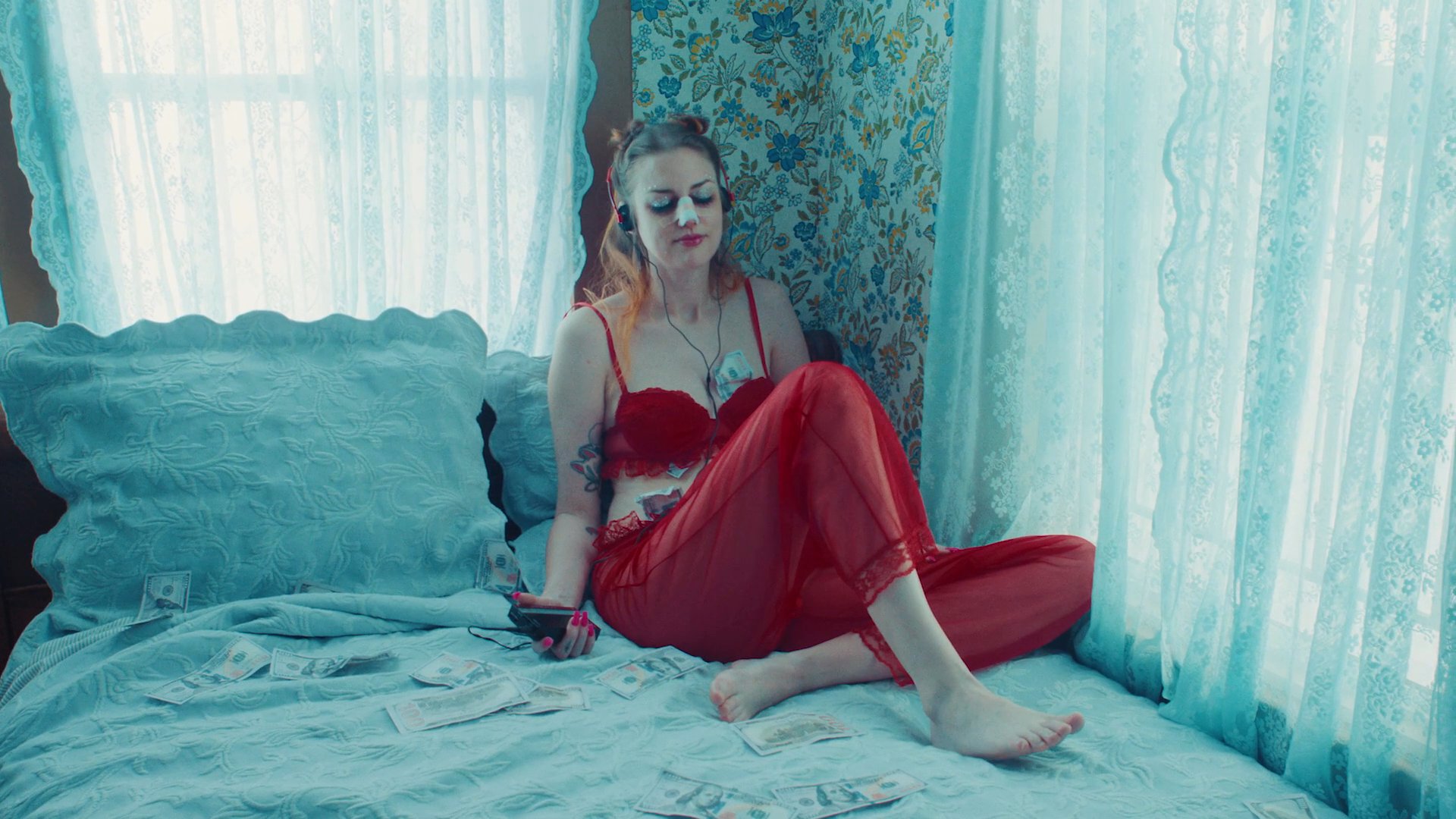 A quiet moment of intimacy between a couple in a living room is abruptly contrasted with scenes of an older man and a young woman in separate, strained domestic settings.