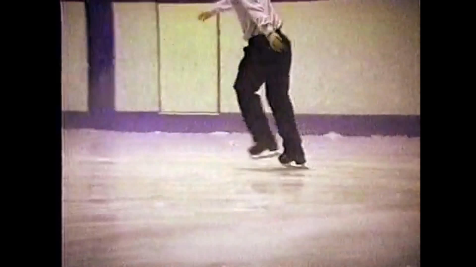 A figure skater performs various maneuvers on an indoor ice rink while patrons dine at tables positioned rink-side.