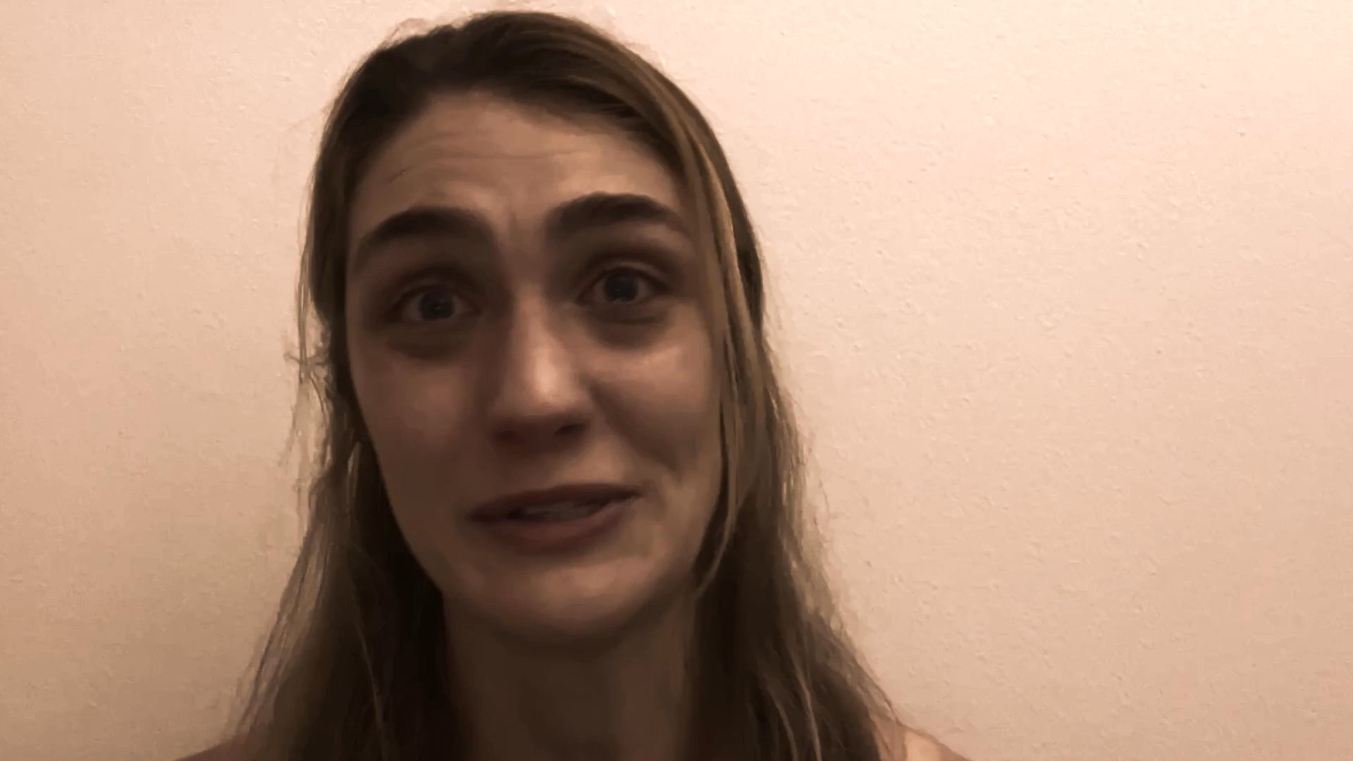 A woman performs a series of distinct facial expressions, transitioning through emotions like surprise, distress, and intensity against a plain backdrop.