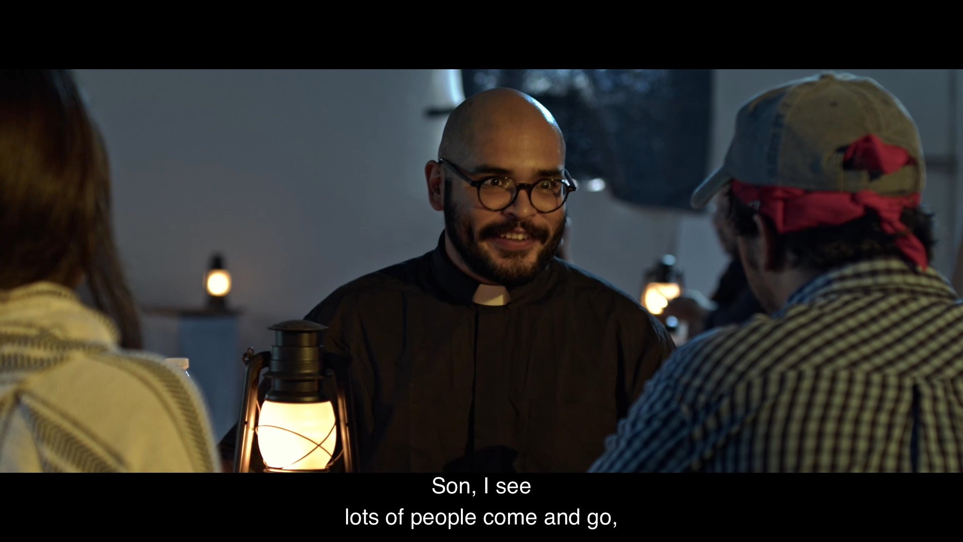 A priest offers counsel to two migrants during an uncertain, late-night conversation about crossing the border.