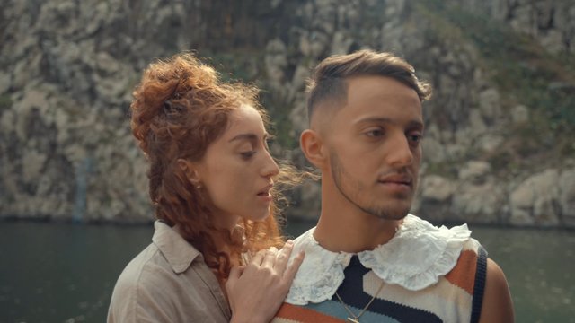 A girl seductively whispering something into her boyfriend's ear