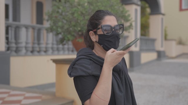 A woman recording a voice message on her smartphone