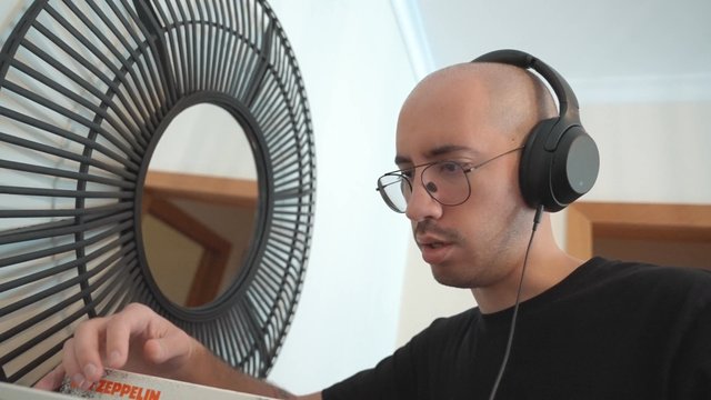 A guy listening to music while flipping through vinyl records