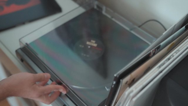 Hands opening a record player