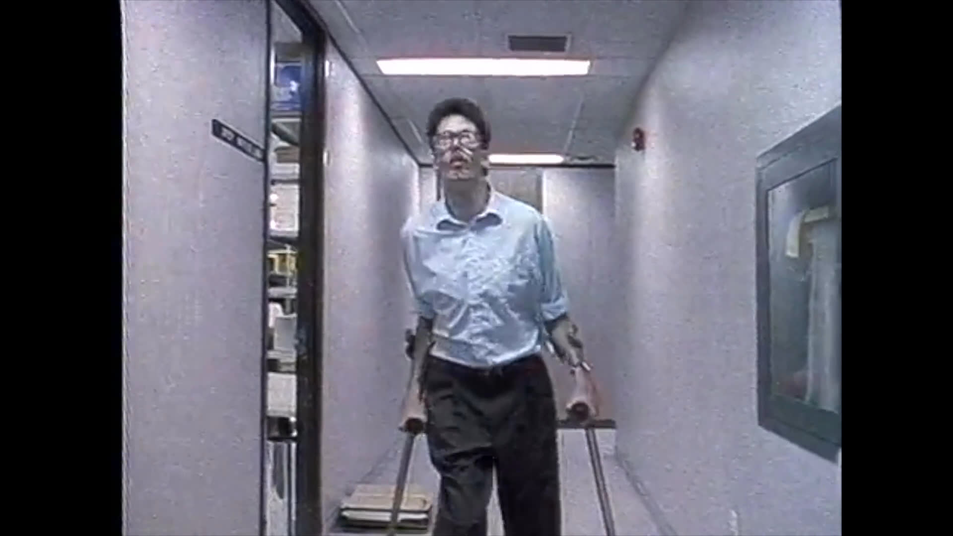 A man navigates a professional office corridor using crutches while transitioning from an exterior entrance to an interior workspace.