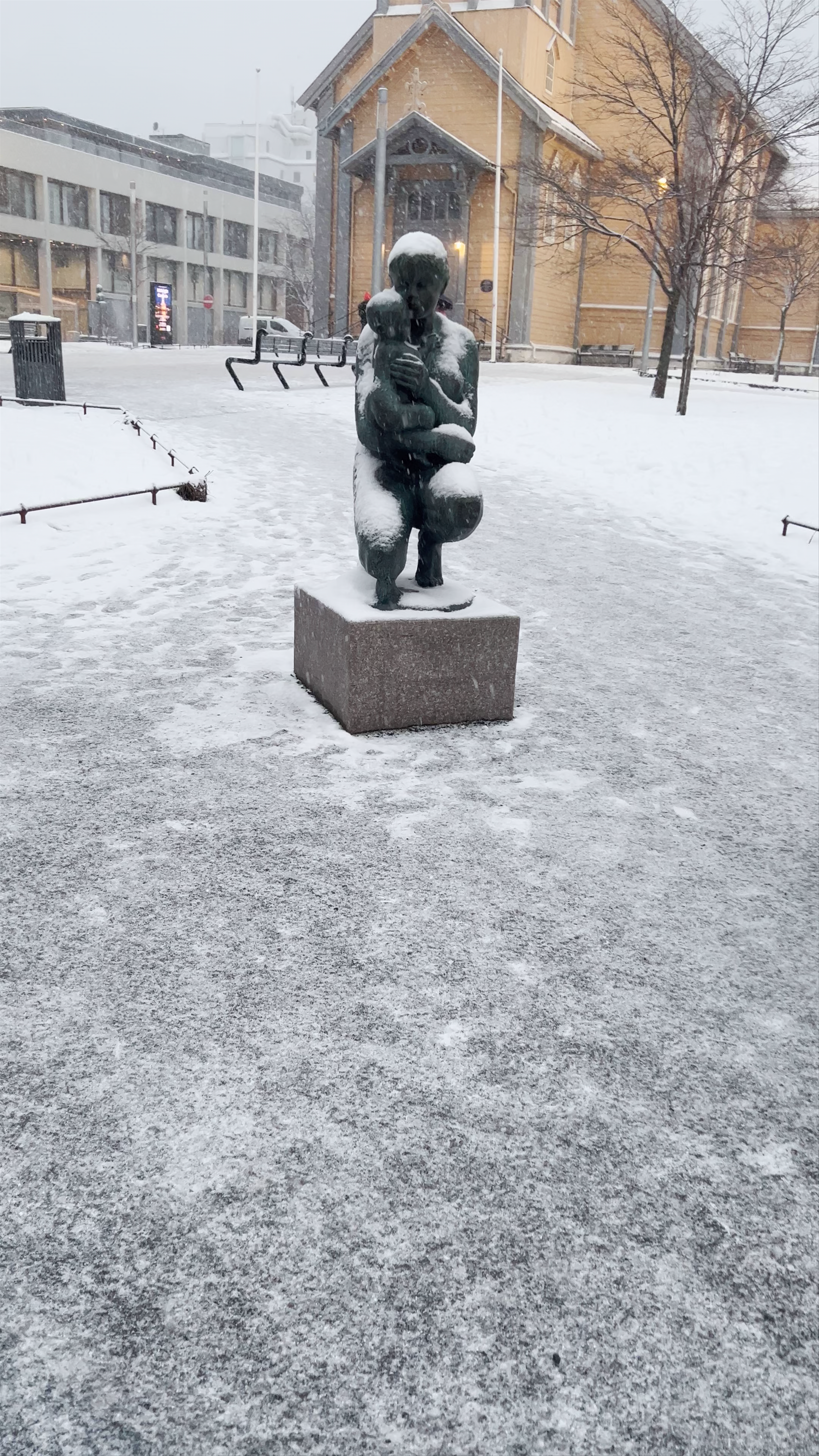 Tromsø Cathedral and Winter Sculpture in a Snowy Nordic Cityscape