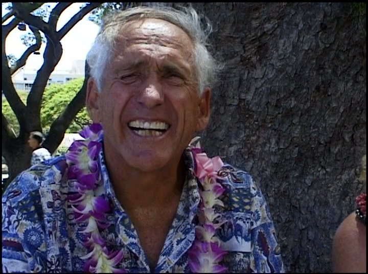 Participants share personal anecdotes and memories regarding their surfing experiences and historical connections to Punahou school. The visual narrative shifts between historical footage and contemporary interviews featuring figures associated with the surfing community.