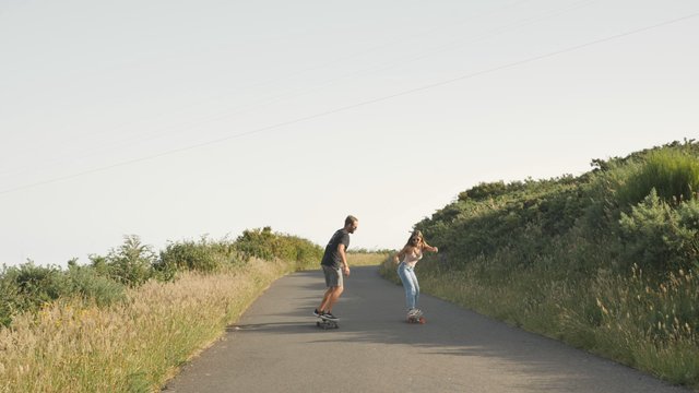 Couple skating on the road 
