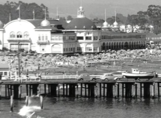 Historical newspaper excerpts detailing local social news transition into a panoramic view of the Santa Cruz coastline, pier, and beach area.