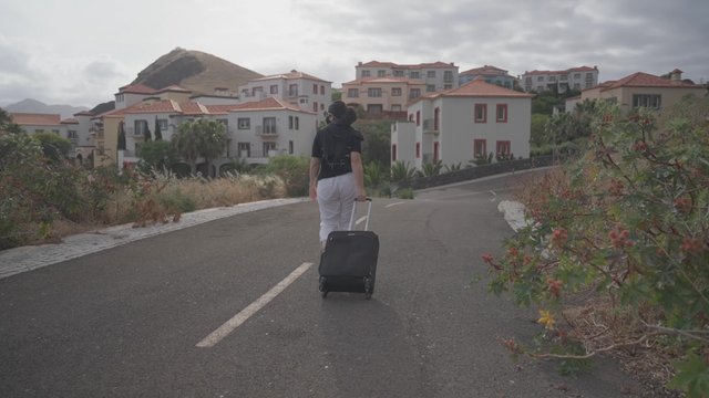 Woman walking down the road with a suitcase