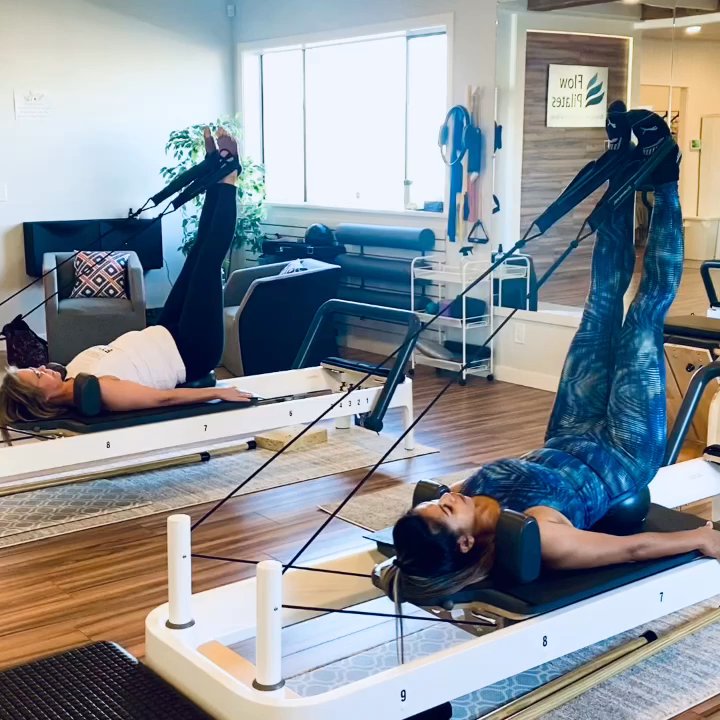 Flow Pilates - Clients with feet in straps doing leg circles. The movement trains mobility&strength in the pelvis&legs, and stability in the core. - Pilates Near Me - Surrey, British Columbia