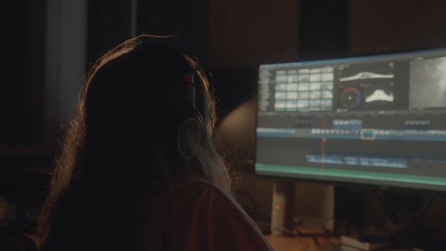 A female video editor taking a break from the process of video editing