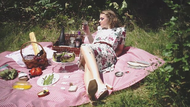 Woman having a drink at a picnic