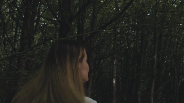 Mujer corriendo en un bosque oscuro