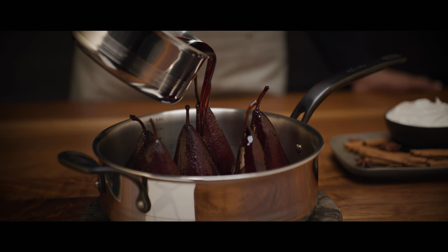 Film still: liquid pouring from a saucepan over pears in an Elite Clad pot