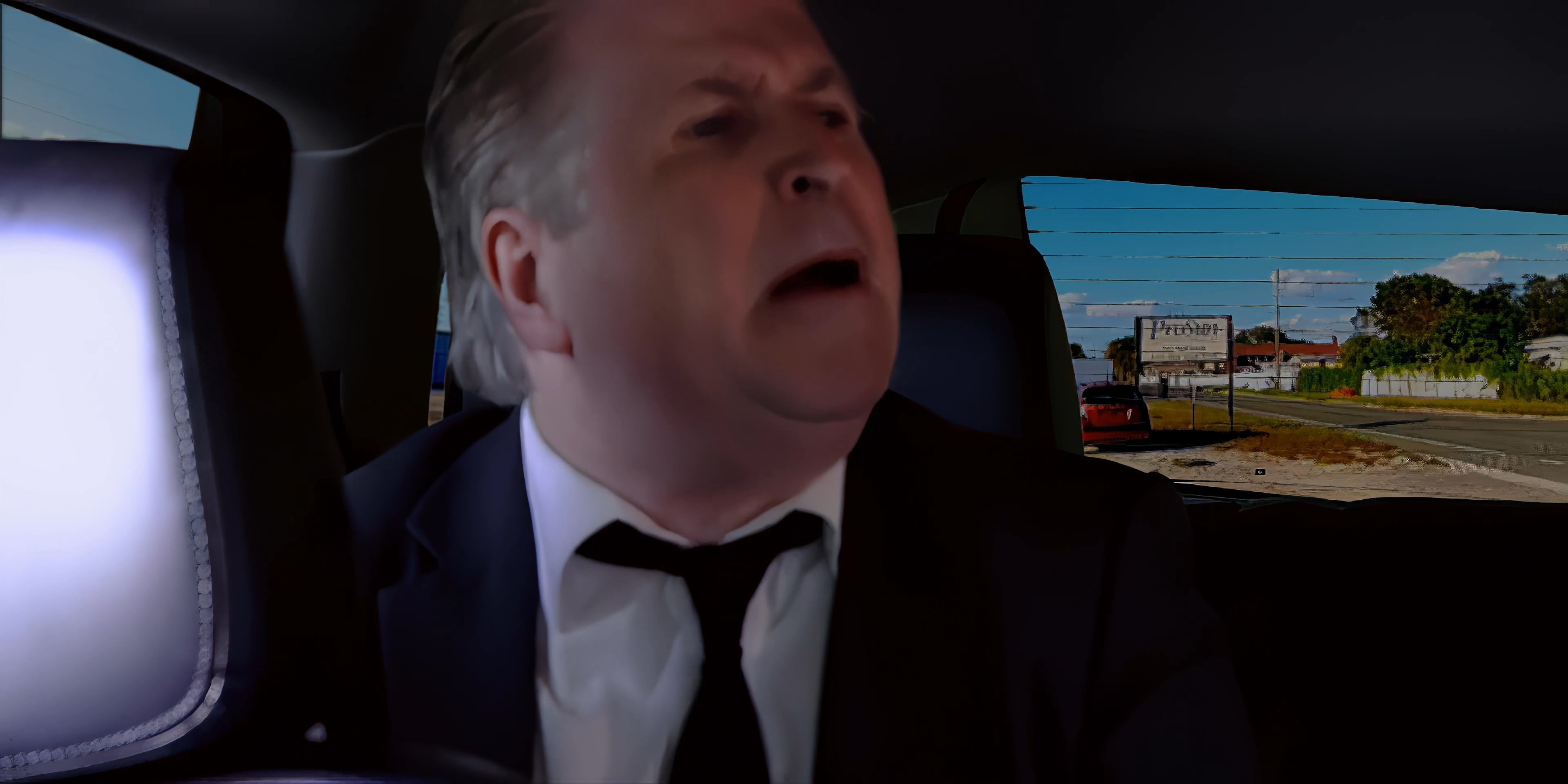 Two individuals engage in a discussion while sitting in the backseat of a vehicle during a commute. The setting shifts between close-ups of each participant as they exchange remarks.