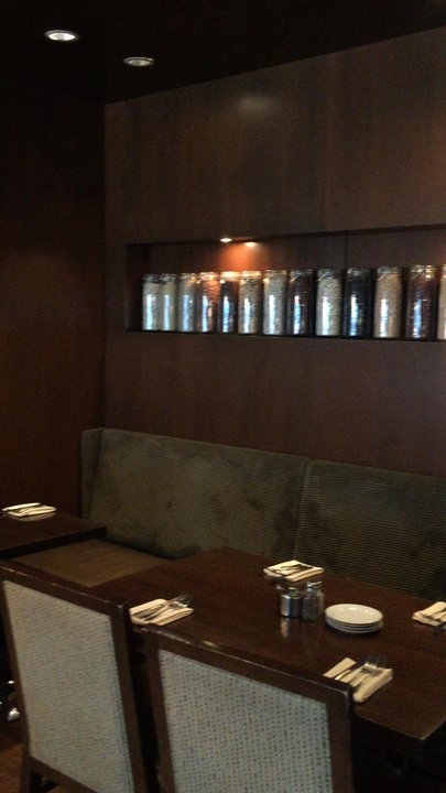 Glen Prairie - Inside starting with tables backed by jars of local organic grains, then the a long table with flowers, and ending with the bar. - Salad Near Me - Glen Ellyn, Illinois