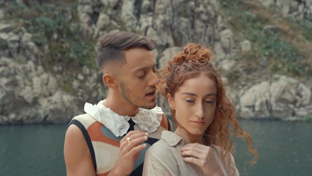 A man speaking into his girlfriend's ear romantically