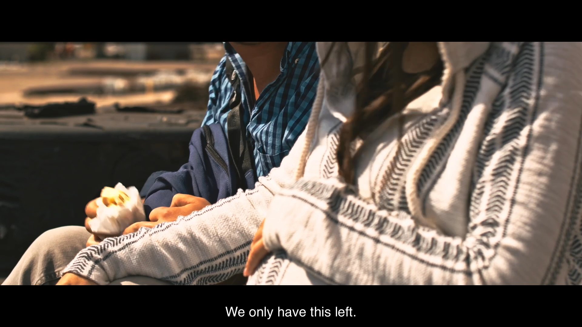 Two travelers riding atop a freight train share a tense conversation regarding their limited food supply. They navigate the harsh conditions of their journey while reflecting on their precarious situation.